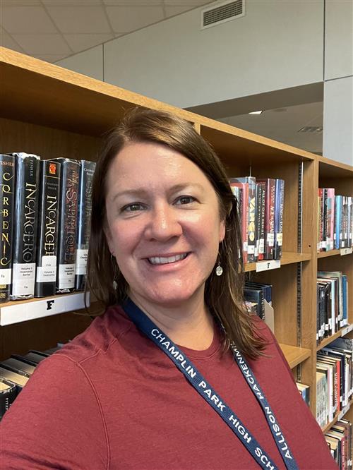 Ms. Hackenmiller in front of book shelves